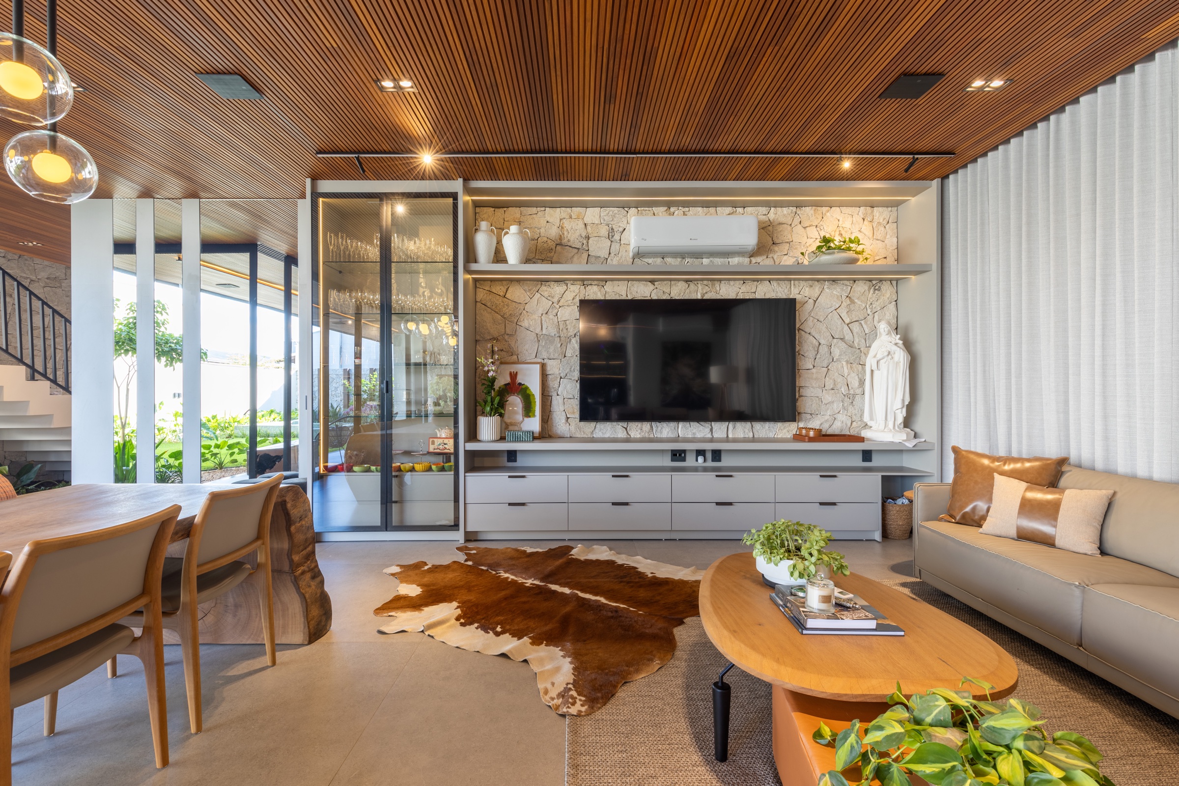 Sala planejada com painel de TV, portas em MDF e marcenaria iluminada